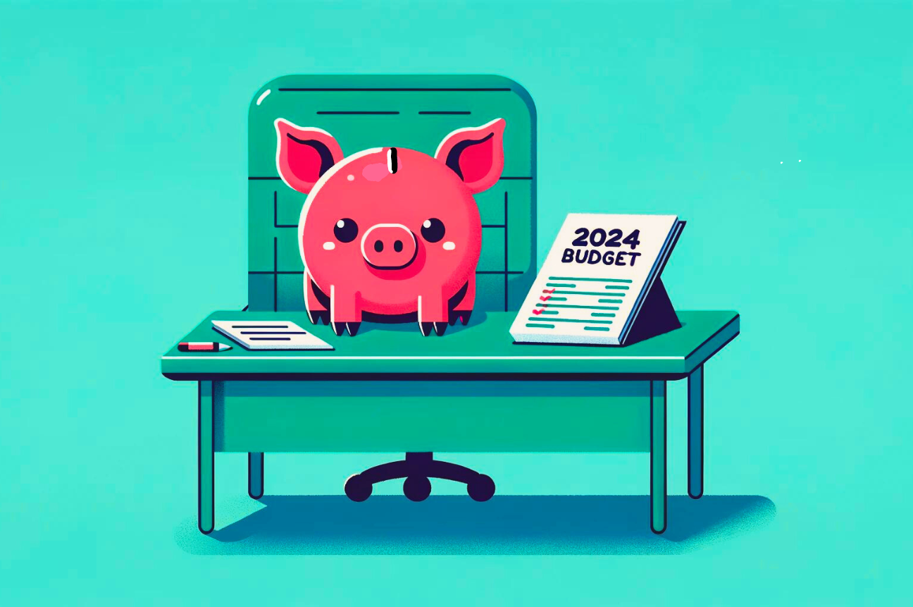 A piggy bank at an office desk planning their recruiting budget for 2024